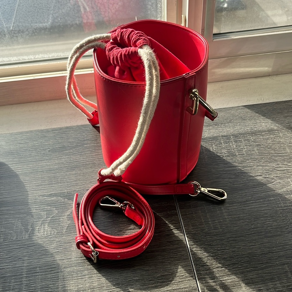 Red bucket bag with gold handle comes with crossbody strap